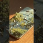 a realistic isometric vertical shot of an Apple iPhone placed on a wooden table, on the phone’s s…